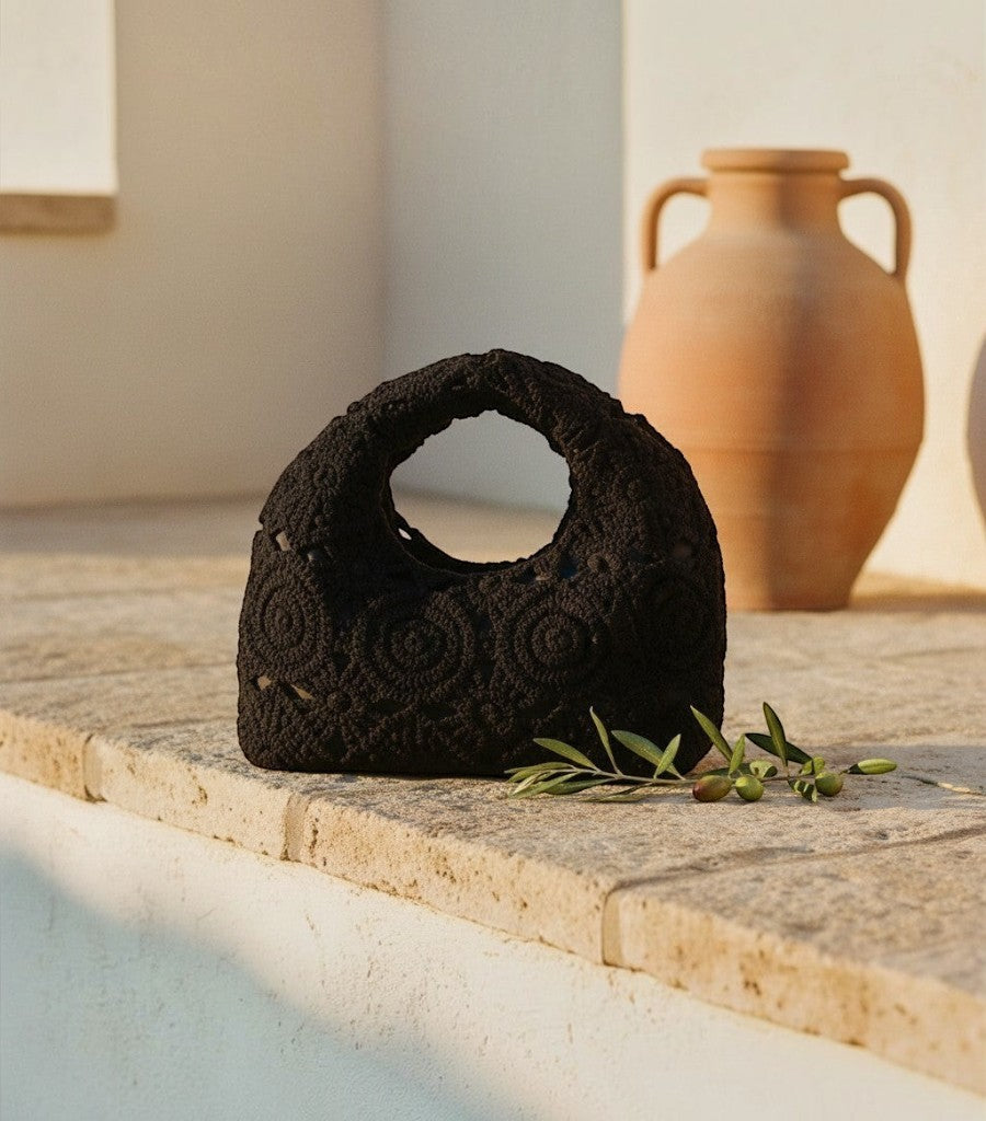 Bolso de rejilla negro de Clarvyna con diseño de crochet circular, ideal para un look elegante y veraniego.
