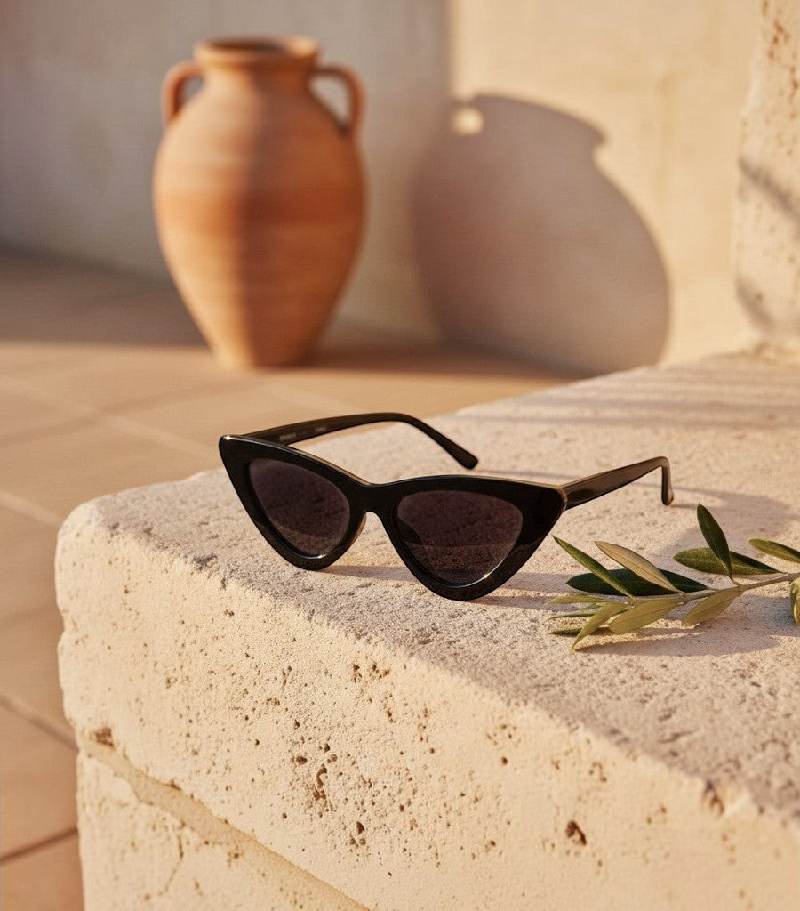 Gafas de sol Cat Eye Walker de Clarvyna en color negro con montura elegante sobre una superficie de piedra