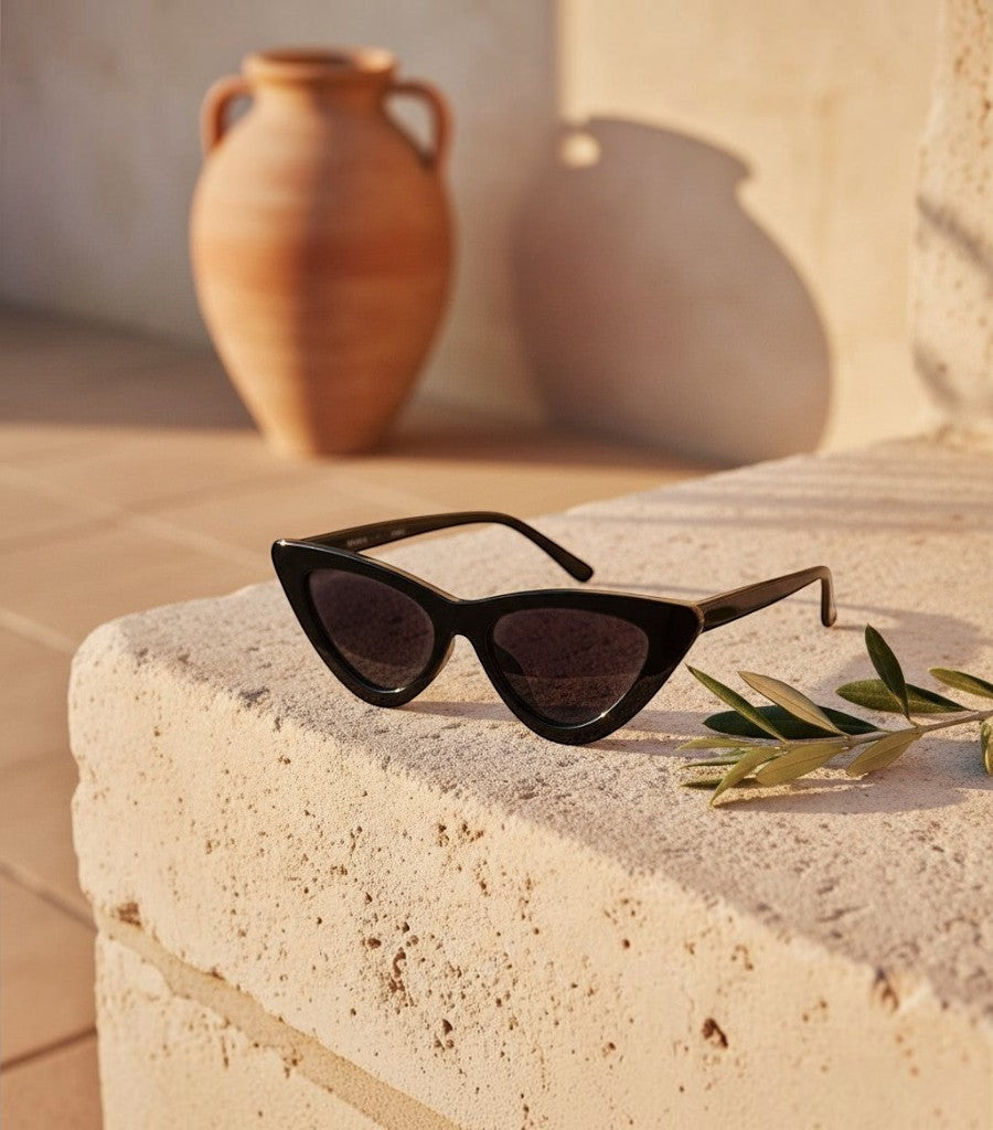 Gafas de sol Clarvyna modelo Cat Eye Walker en color negro sobre una superficie de piedra con luz cálida