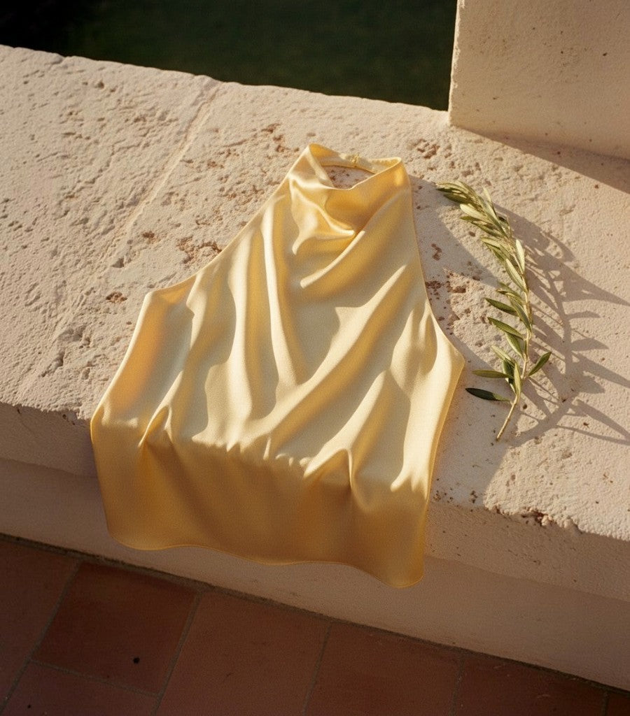 Top corsé halter de satén amarillo Clarvyna con acabado brillante, ideal para un look de verano elegante y fresco.