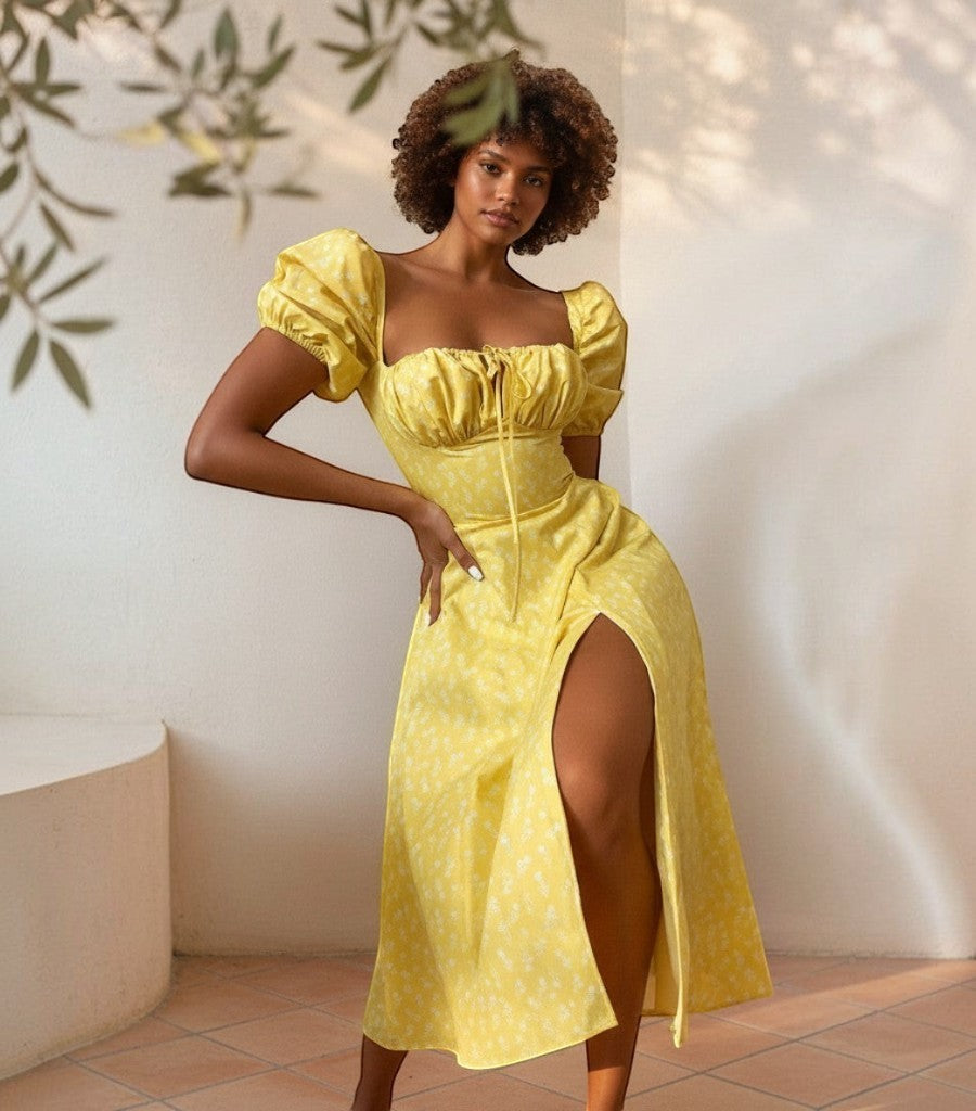 Modelo con vestido Clarvyna Amada amarillo de flores con mangas abullonadas y abertura lateral en entorno soleado