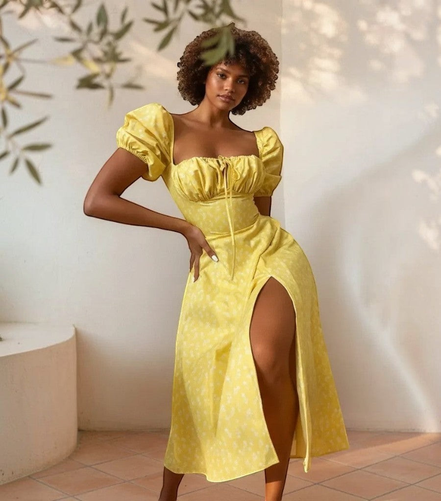 Modelo posando con vestido Clarvyna amarillo de manga abullonada, escote fruncido y abertura lateral en la pierna.